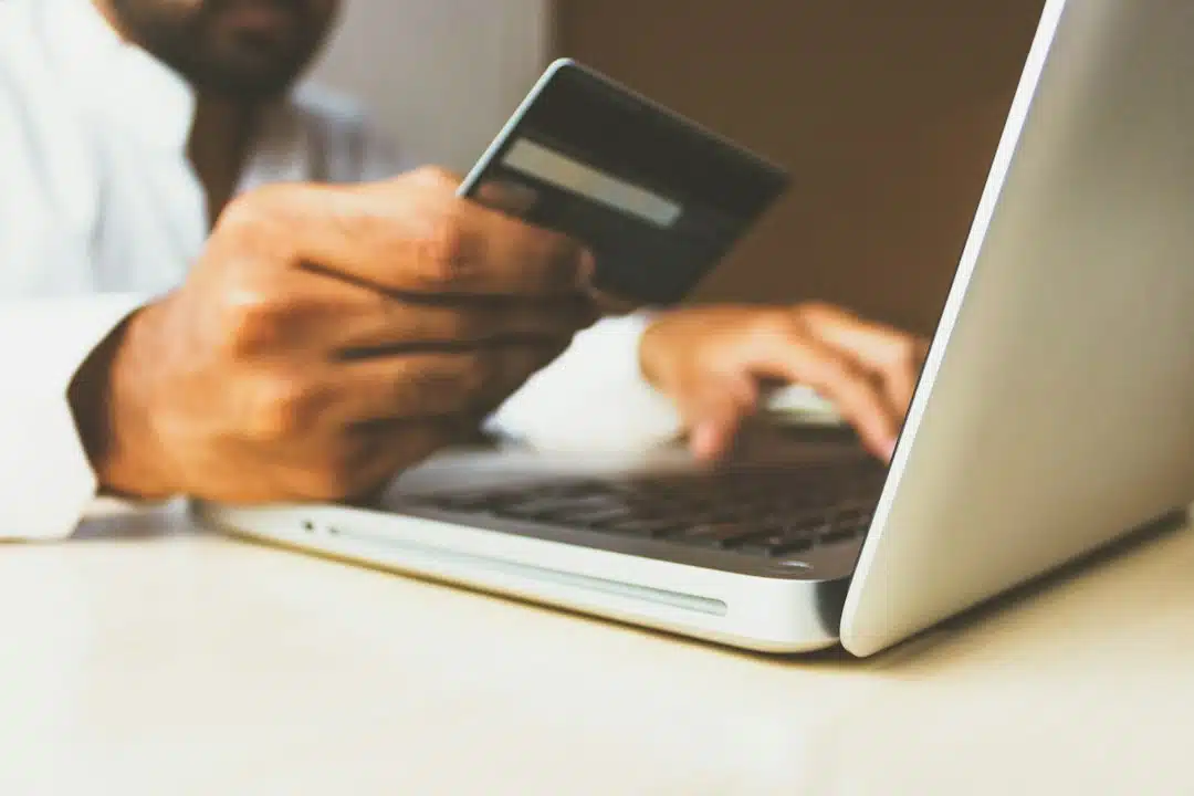 Shopper holding a credit card while paying online on a laptop